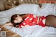 A woman in a red dress laying on a bed.