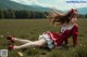 A woman in a red dress laying in a field.