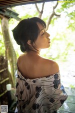 A woman in a black and white dress looking out a window.
