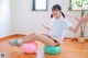 A woman sitting on an exercise ball in a room.