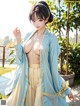 A woman in a blue kimono is posing for the camera.