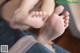 A close up of a person's feet on a chair.