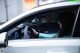 A woman sitting in the driver's seat of a white car.