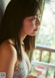 A woman in a white dress looking out a window.