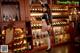 A woman in a maid outfit standing in front of a wine rack.